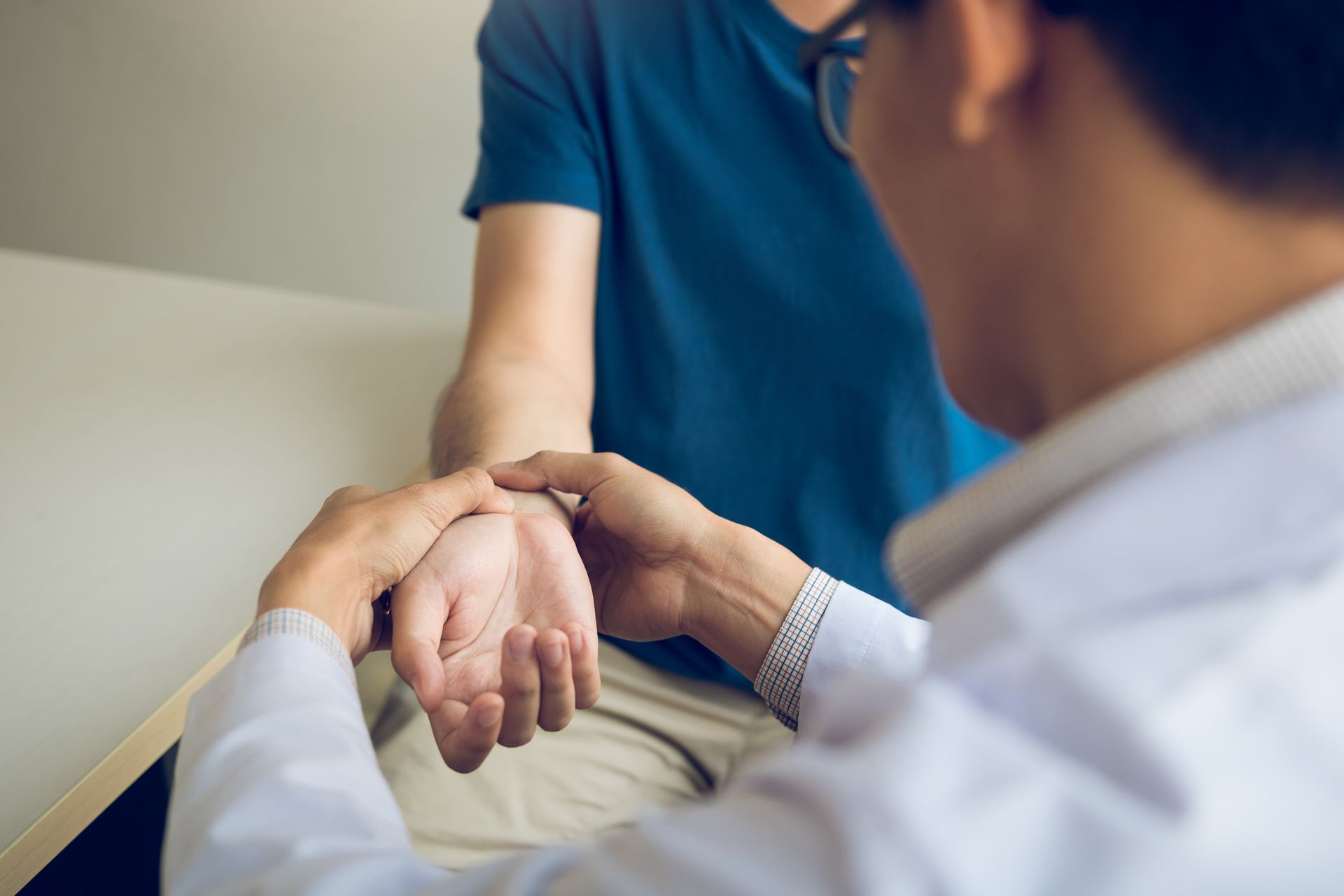 A medical professional checks a patient’s radial pulse at the wrist.