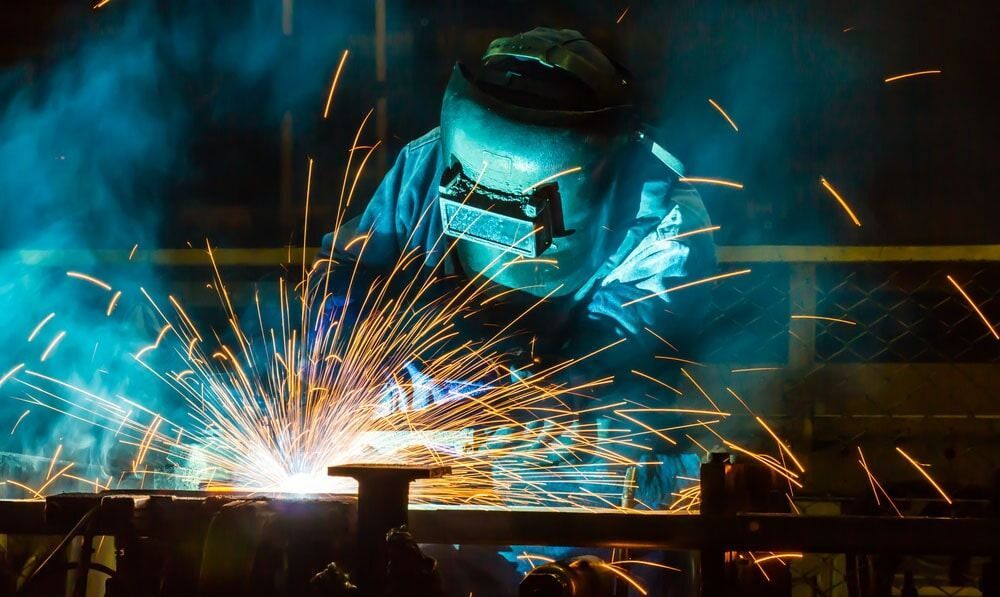A Man Is Welding a Piece of Metal in A Factory — North Coast Steel in South Kempsey, NSW