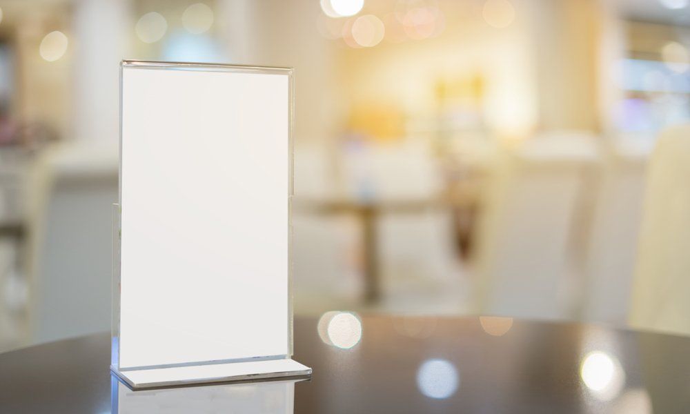 A White Sign Is Sitting on A Table in A Restaurant — North Coast Steel in Wauchope, NSW