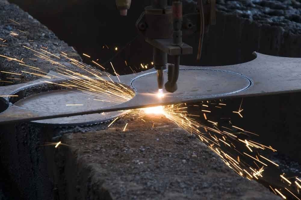 A Machine Is Cutting a Piece of Metal with Sparks Coming out Of It — North Coast Steel in South Kempsey, NSW