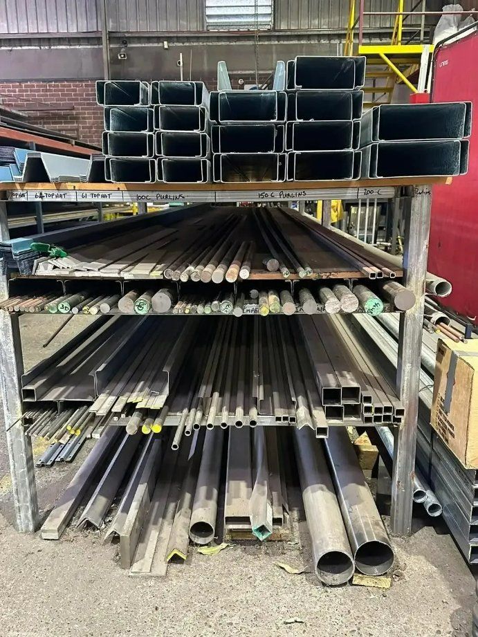 A Bunch of Metal Pipes Are Stacked on Top of Each Other on A Shelf — North Coast Steel in Wauchope, NSW