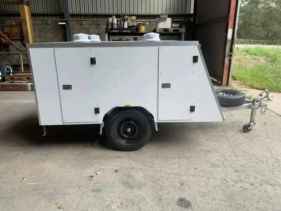 A White Trailer Is Parked in Front of A Garage Door — North Coast Steel in Wauchope, NSW
