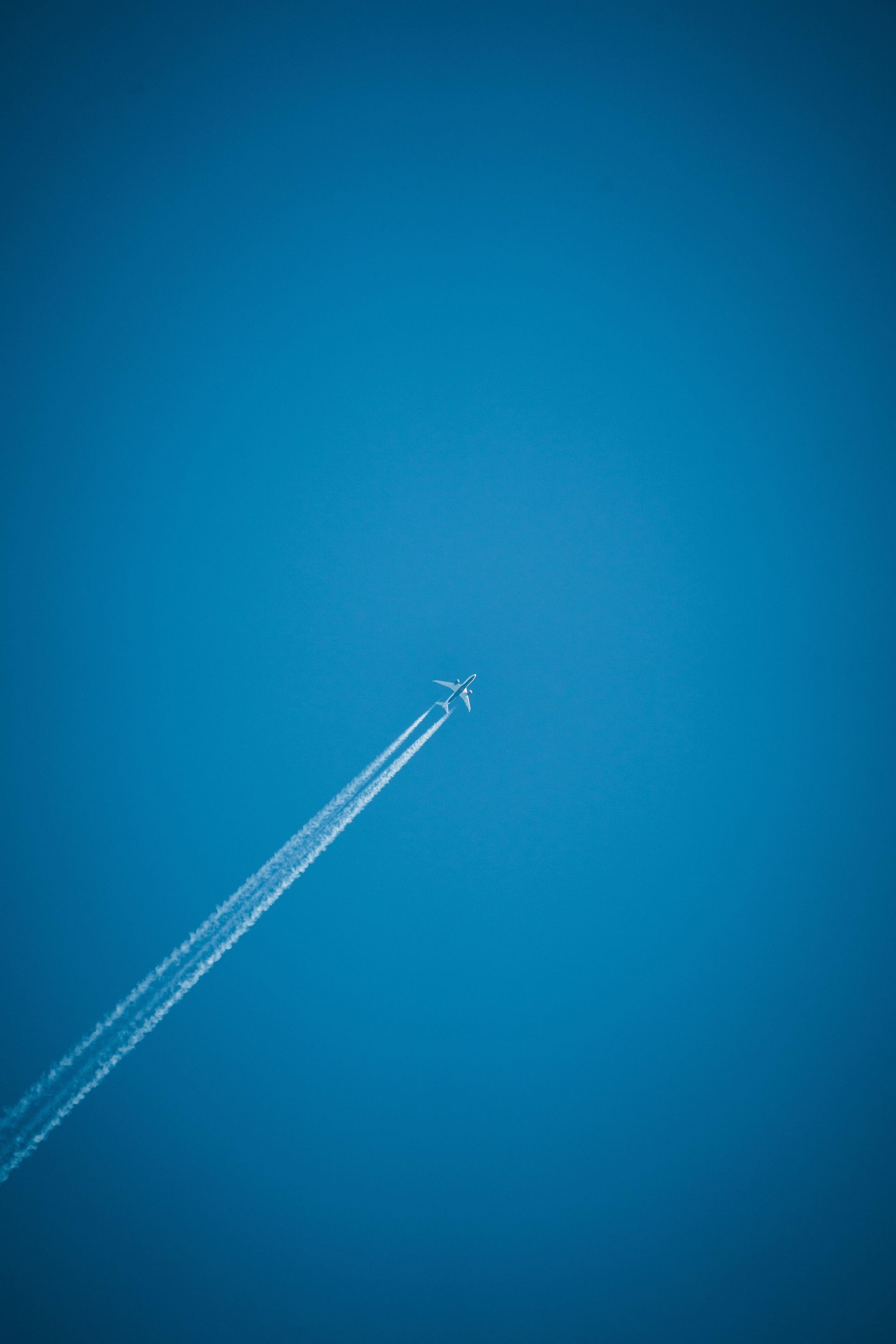 Airplane contrail across a clear, blue sky.