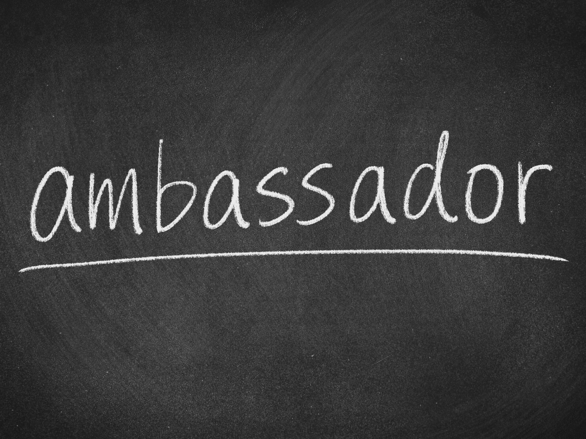 The word ambassador is written in white chalk on a blackboard