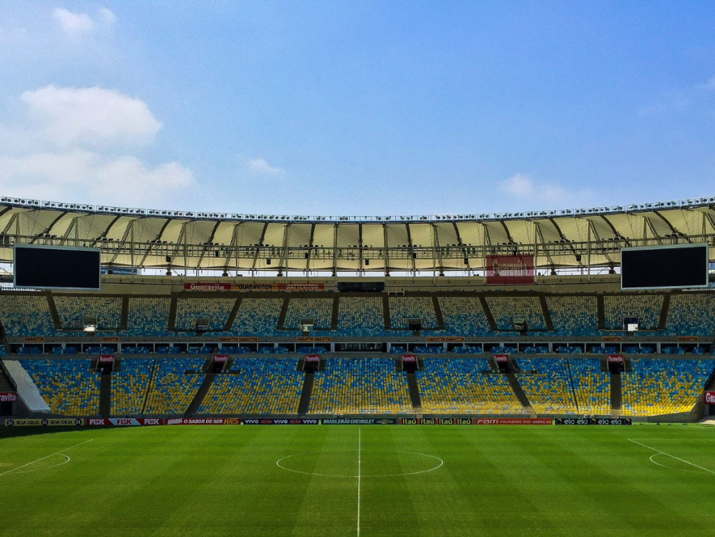 An empty soccer stadium with a blue sky in the background.