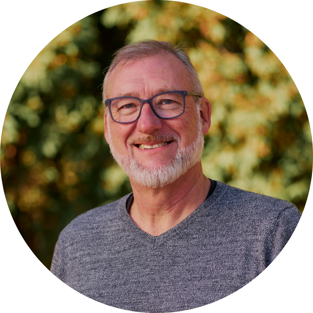 A man with glasses and a beard is smiling in a circle