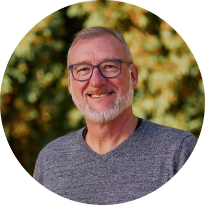 A man with glasses and a beard is smiling in a circle