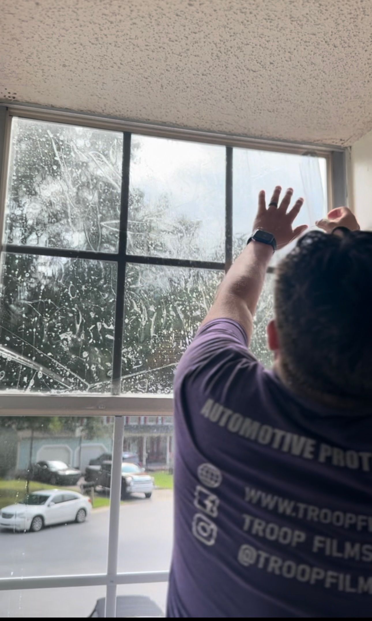 a person is cleaning a window with a sponge .