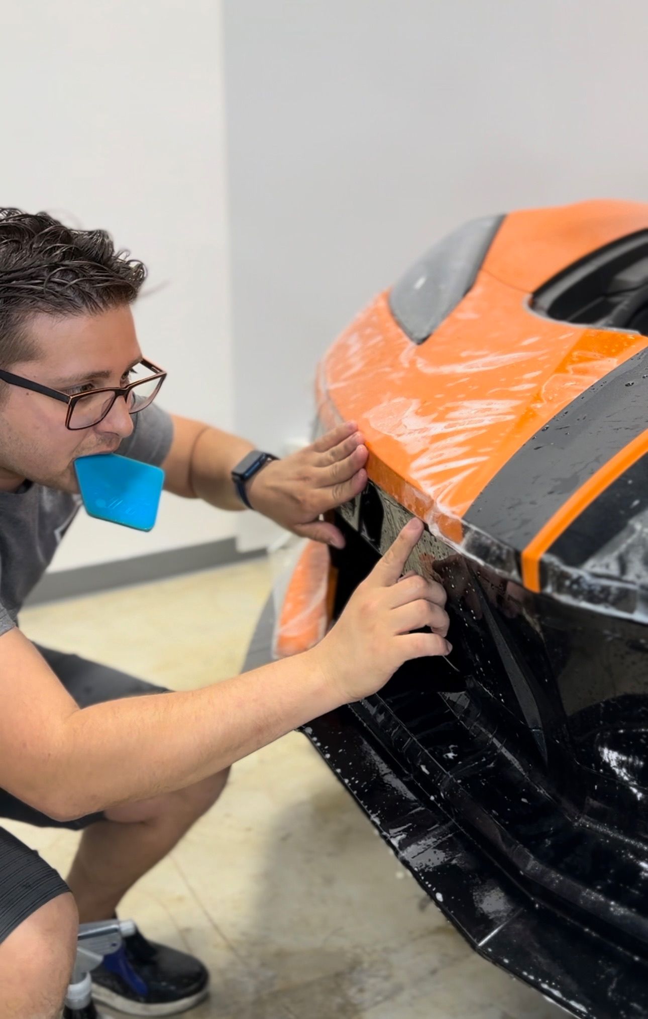 a man is wrapping a car with plastic wrap .