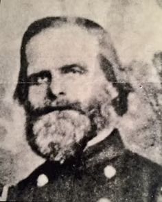 A black and white portrait of a man with a full beard and uniform.