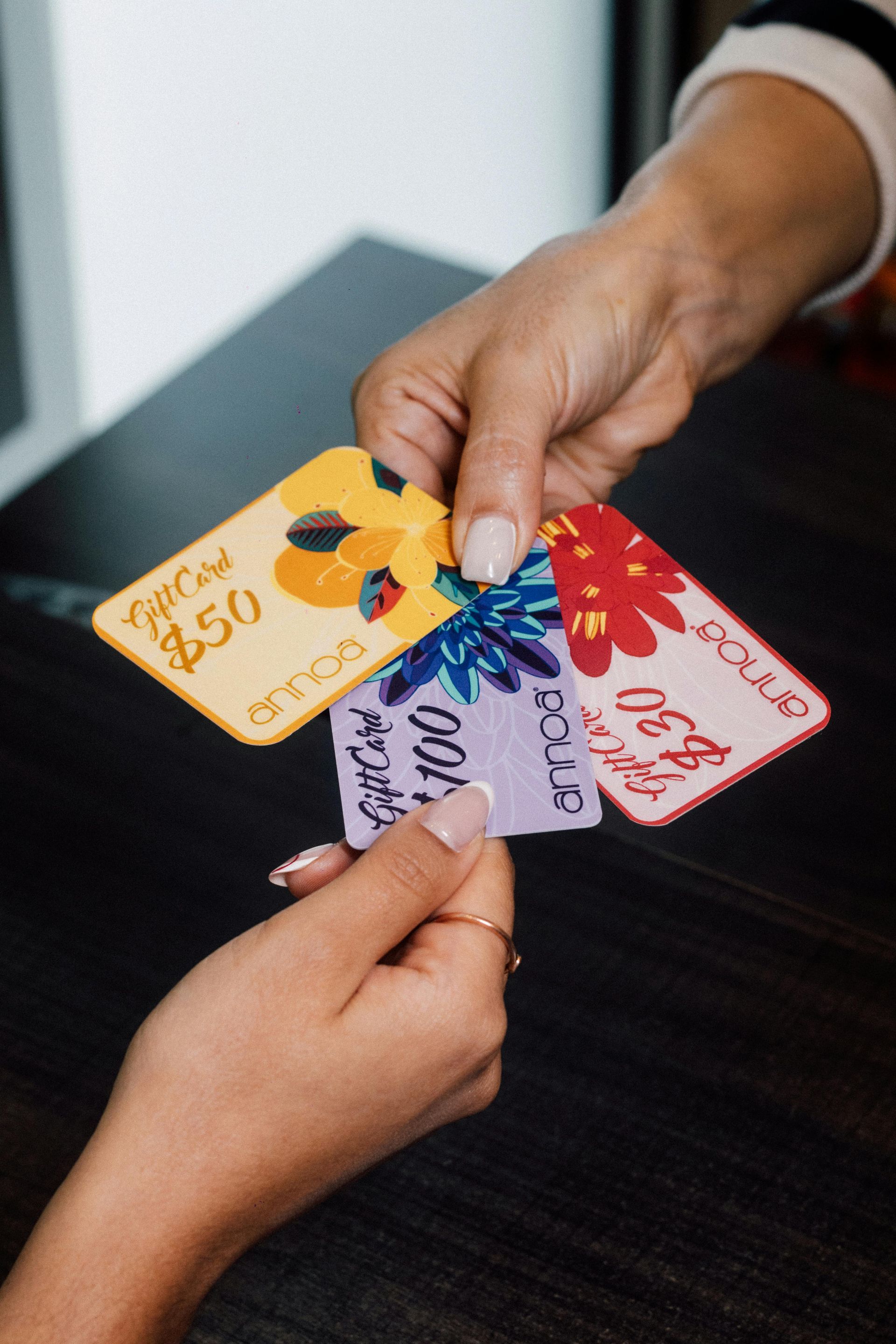 Hands exchanging colorful gift cards.