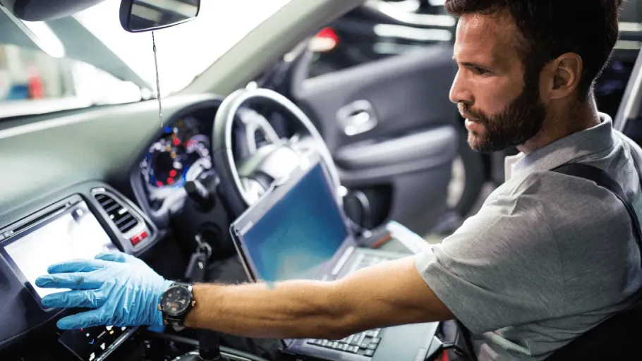 Mechanic running car diagnostics using a laptop