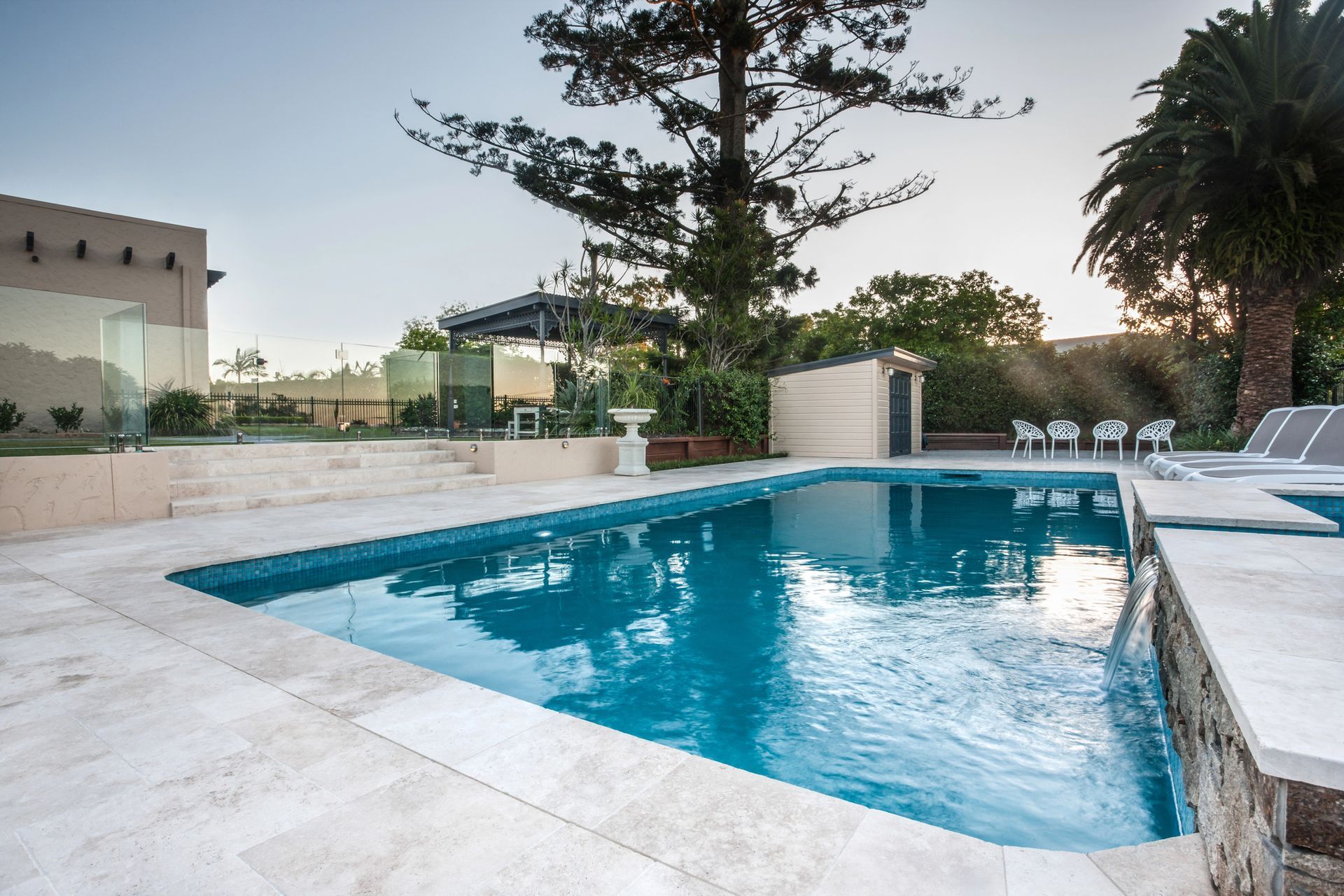 A large swimming pool with palm trees in the background. A large swimming pool with palm trees in the background.
