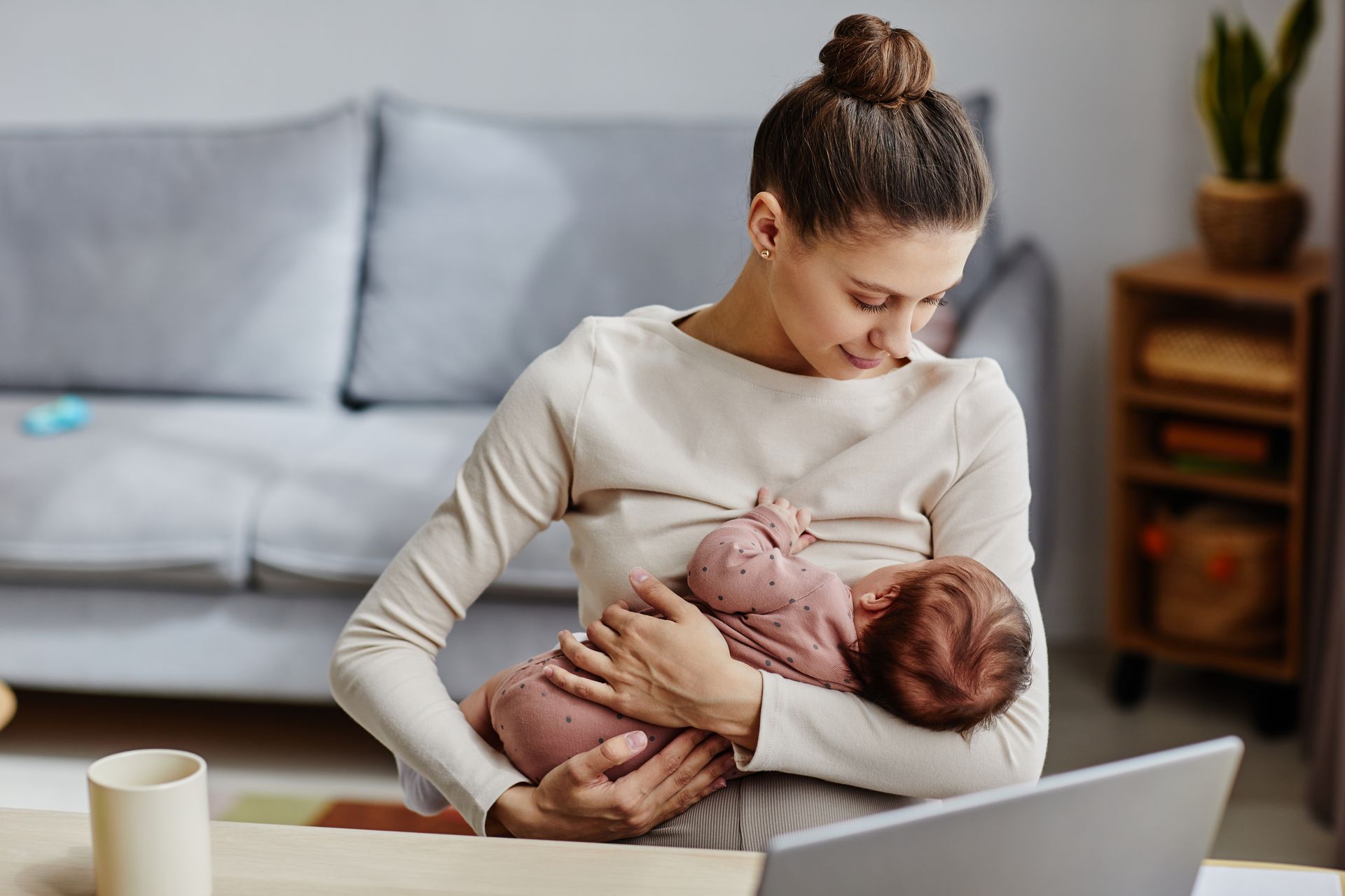 A woman is nursing a baby