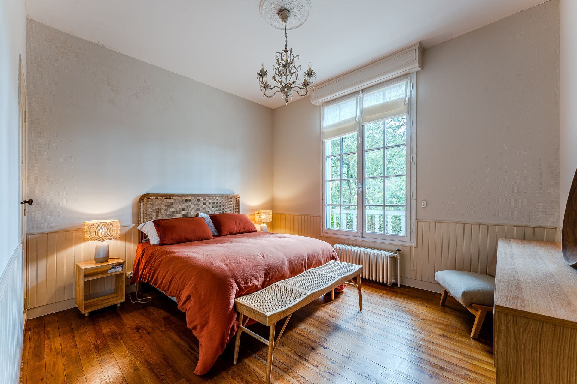 Une chambre avec un lit, une commode, une table de chevet, une chaise et une fenêtre.