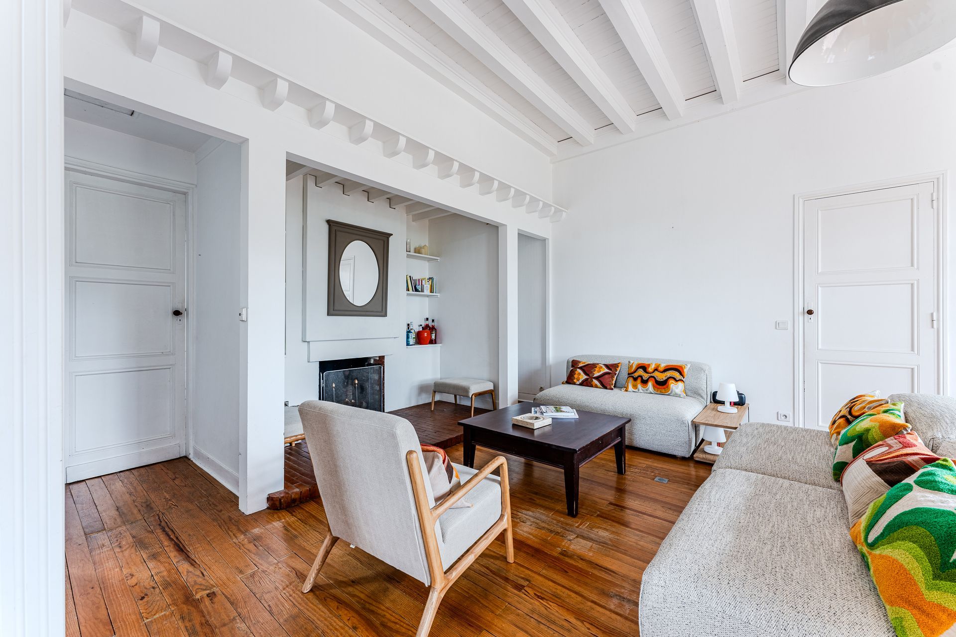 Un salon avec un canapé, une chaise, une table basse et une cheminée.