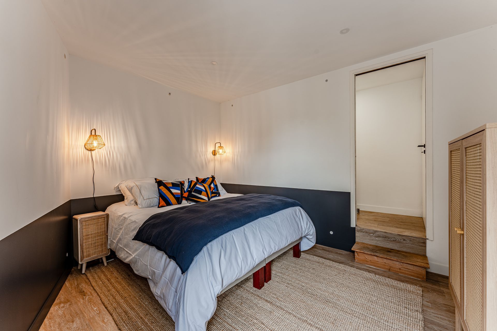 Il y a un grand lit au milieu de la pièce.