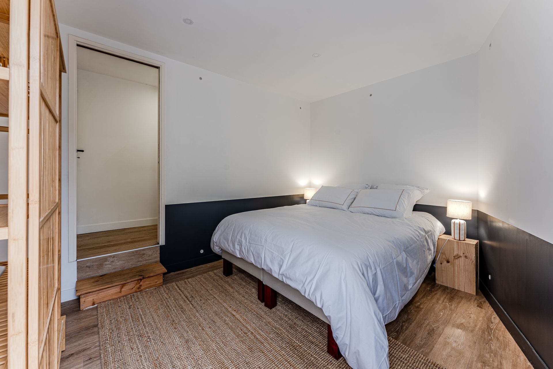 Il y a un grand lit au milieu de la pièce.