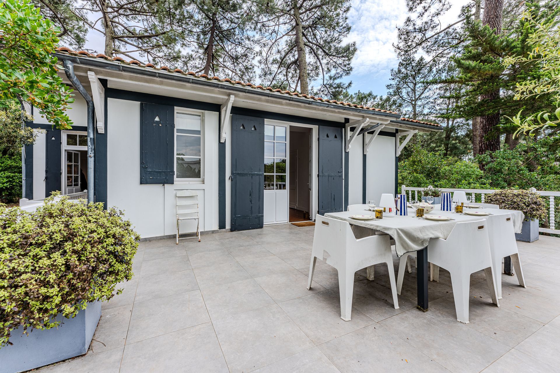 Un patio avec une table et des chaises devant une maison