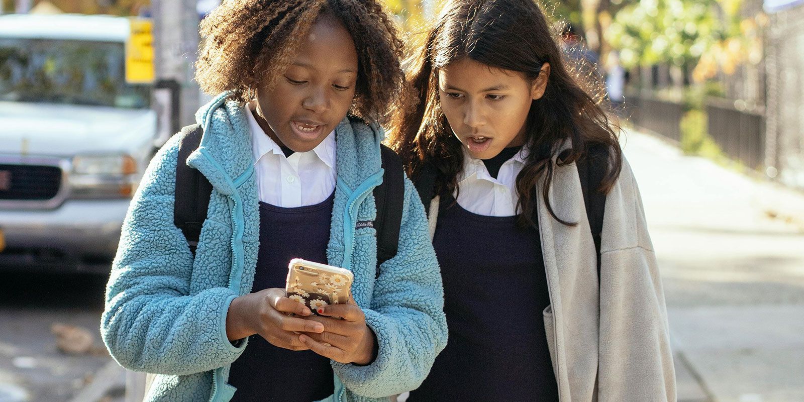 Two female school students looking at a mobile phone