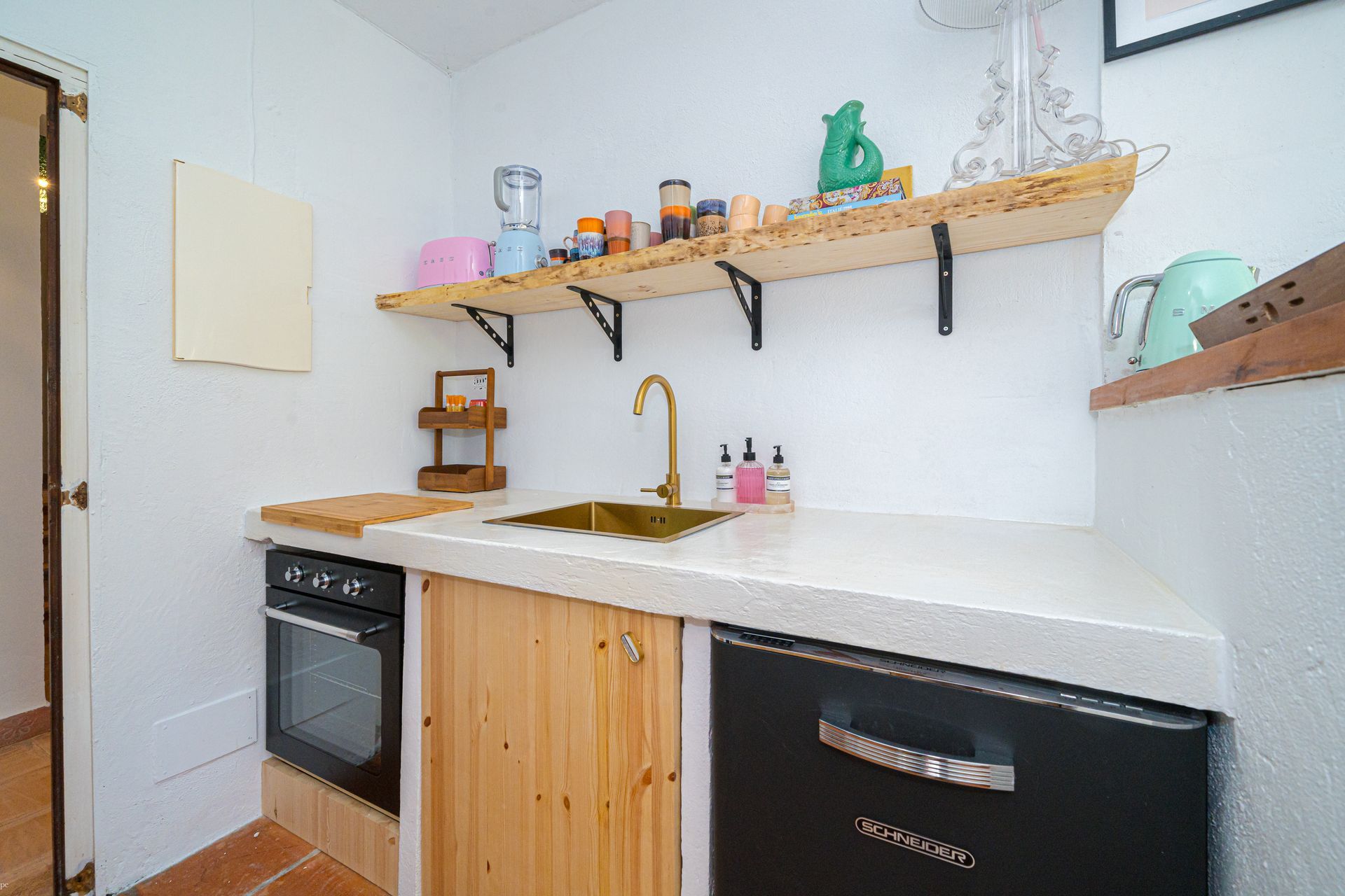 Una cocina con gabinetes de madera y lavavajillas negro de Villa Fave en Jávea.