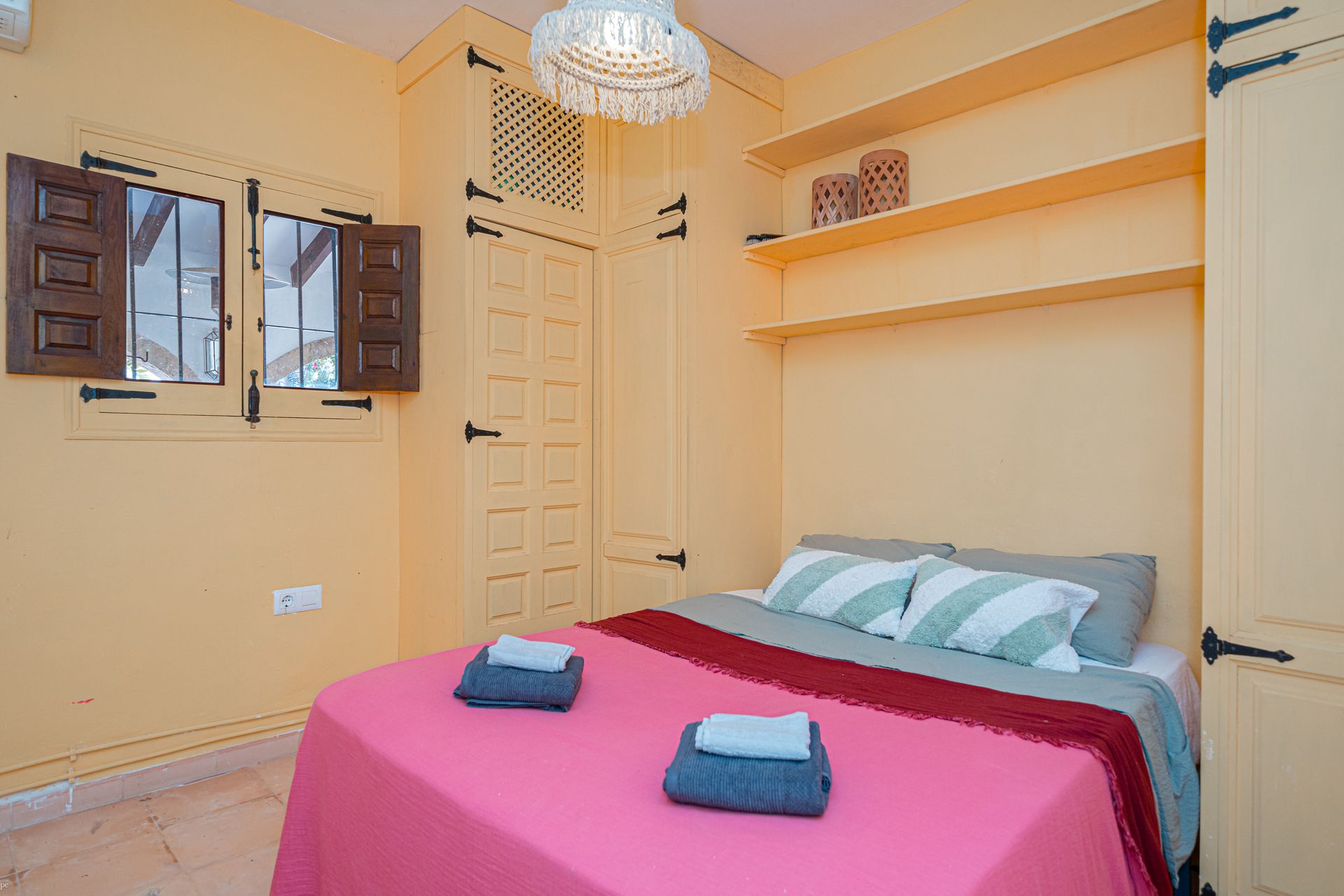 Een slaapkamer met een roze bed en een raam van Villa Fave in Javea 