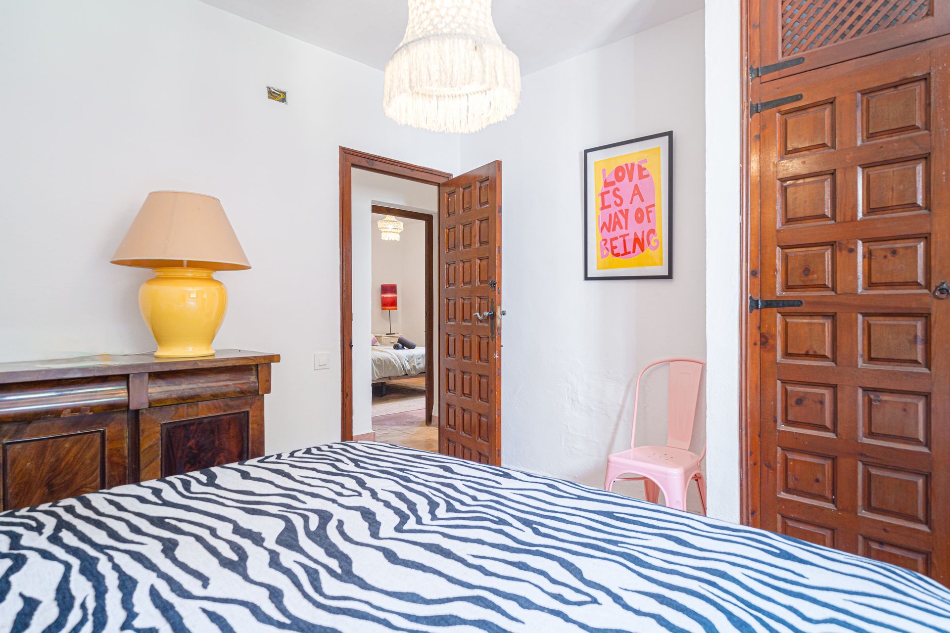 Een slaapkamer met een zebraprintbed en een lamp