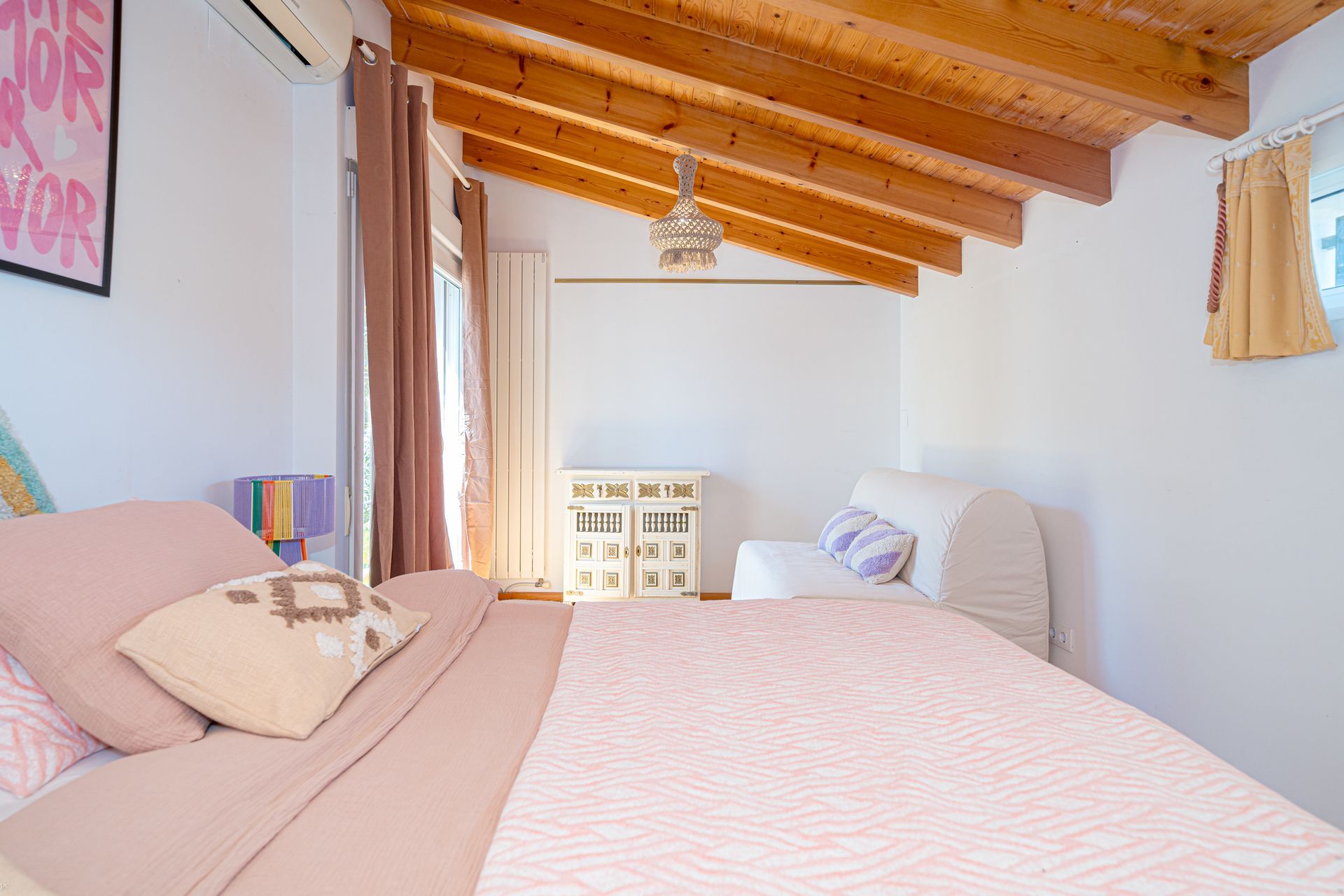 Un dormitorio con techo de madera y una cama.