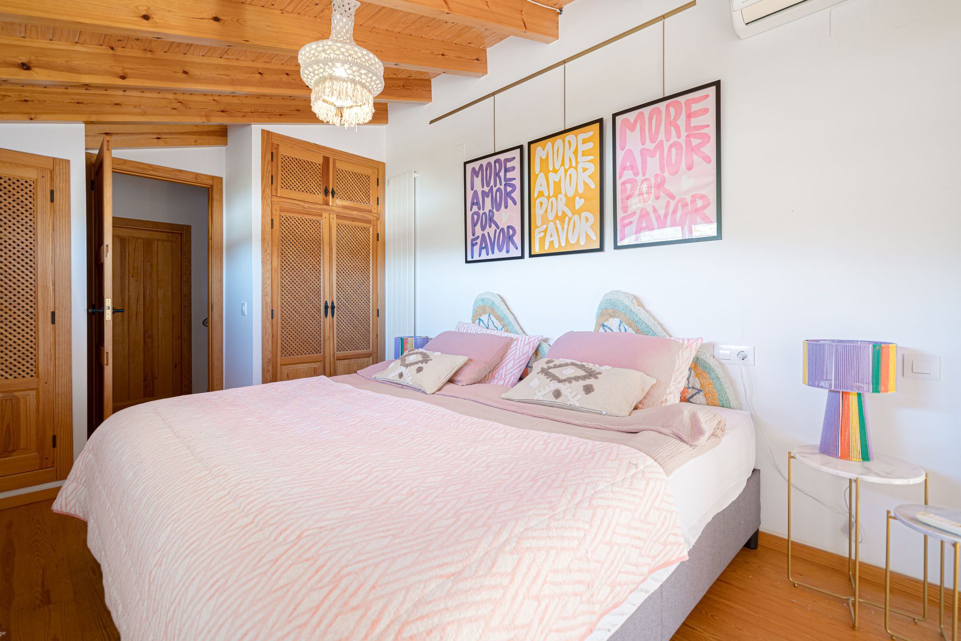 Un dormitorio con una cama grande y una lámpara de arcoíris.