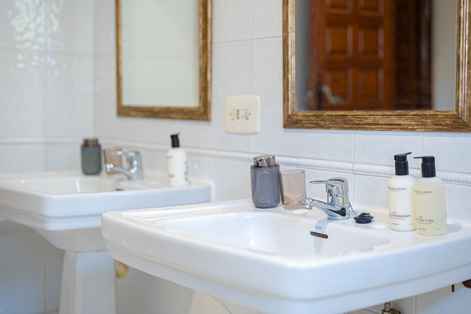 Ein Badezimmer mit zwei Waschbecken und zwei Spiegeln