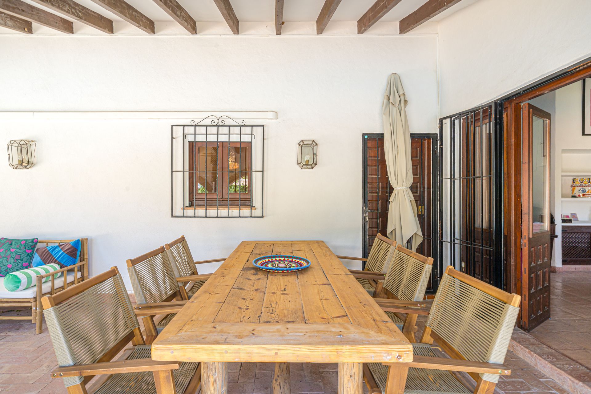 Een houten tafel en stoelen in een kamer met een raam