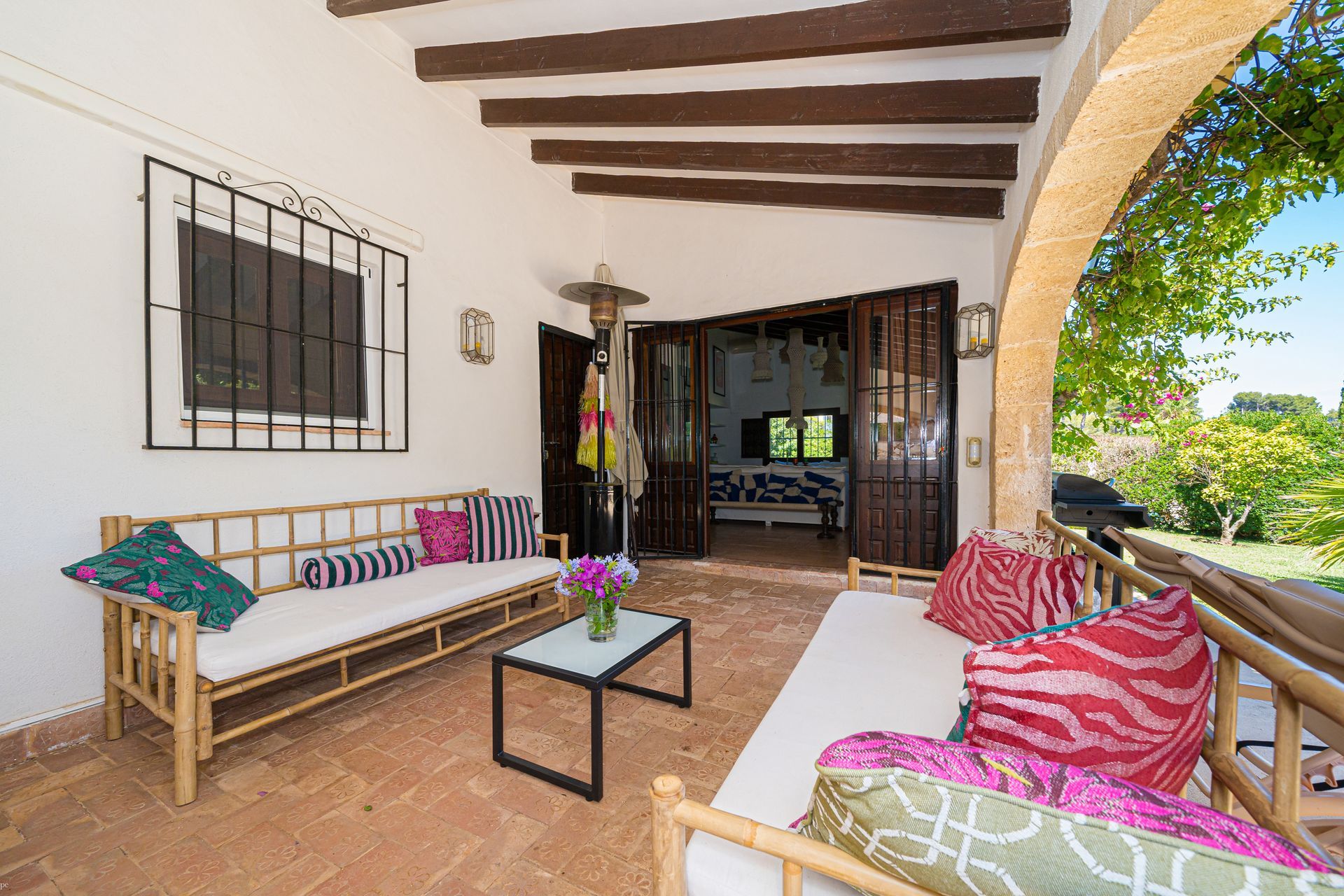 Un patio con un sofá y una mesa con una piscina al fondo de Villa Fave en Xabia, El Tosalet.