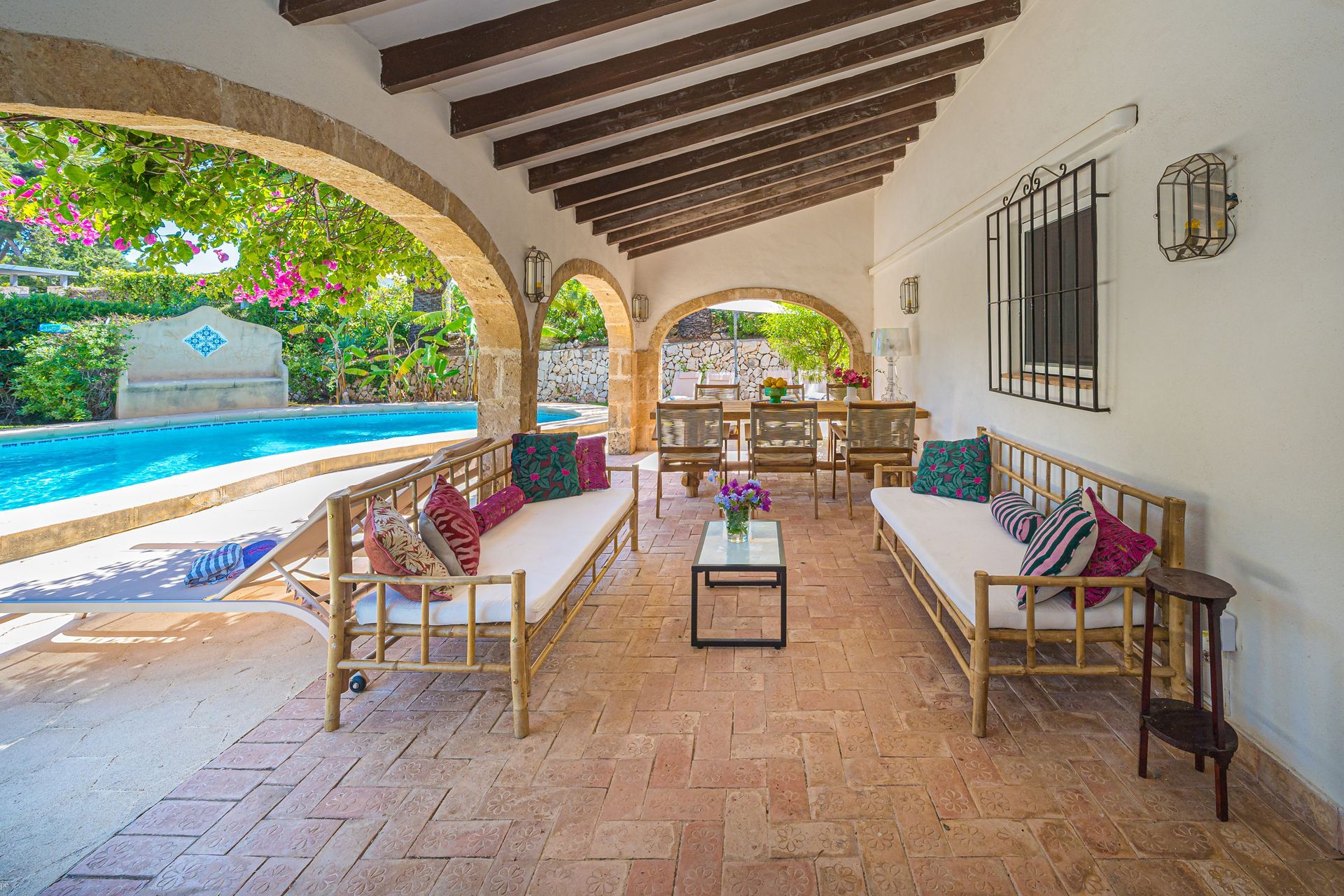 Een patio met een zwembad op de achtergrond