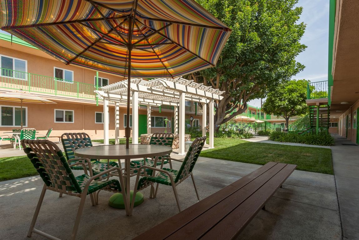A patio with a table and chairs under an umbrella