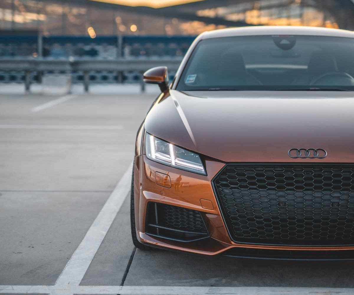 polished bronze Audi parked in an empty lot