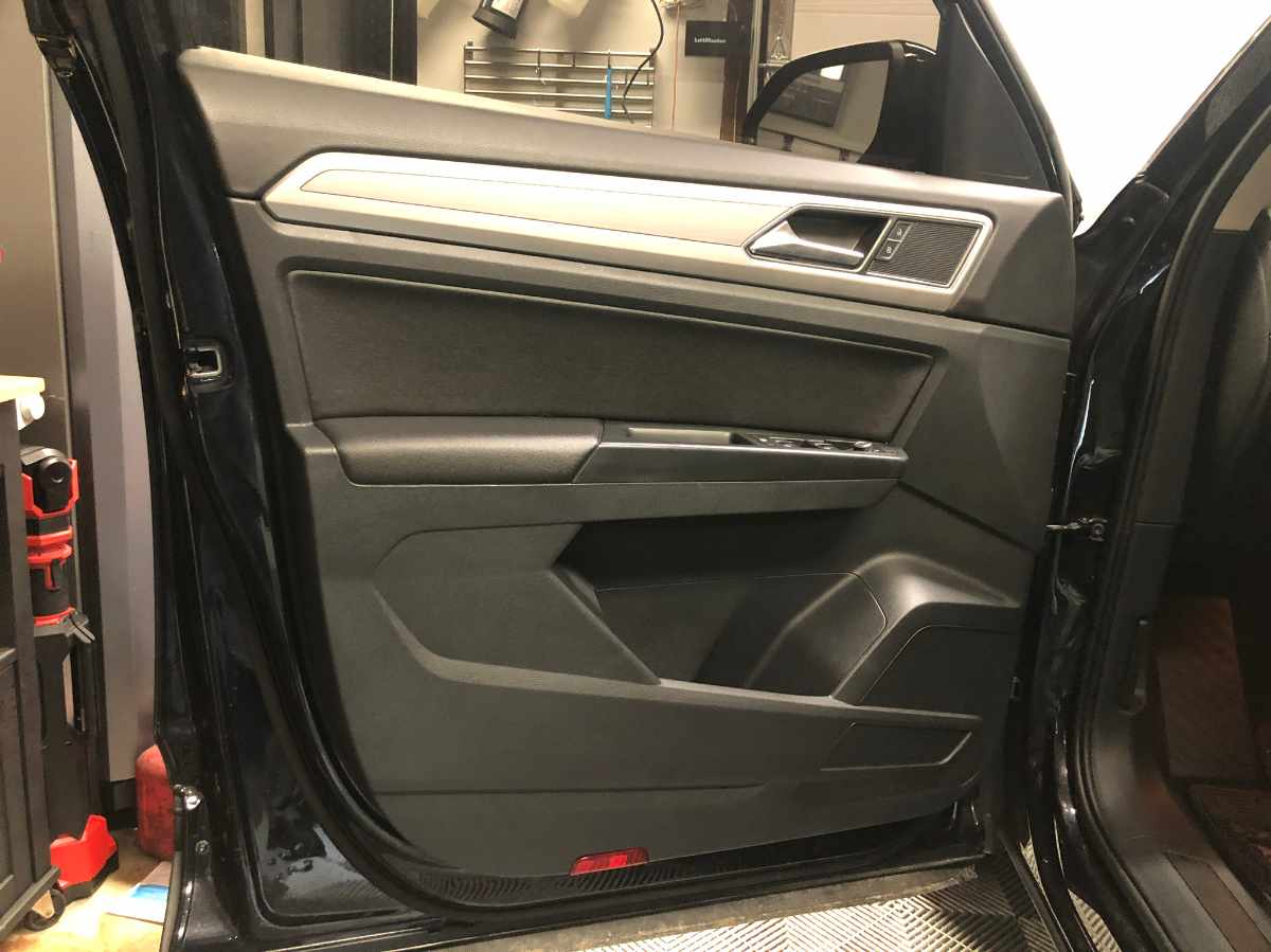 Black car door panel, silver accents, door open, interior view.