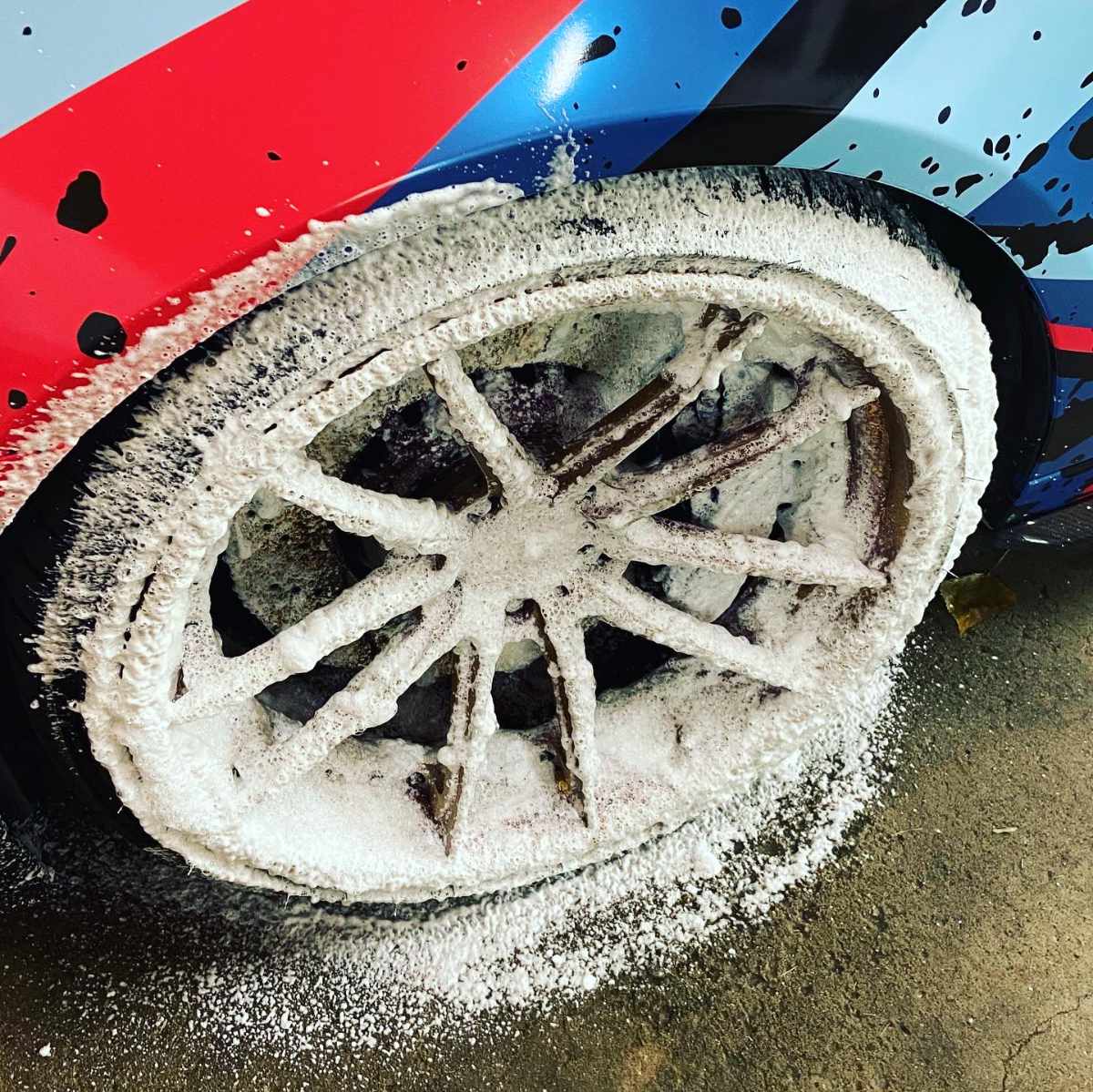 foam on the wheel of custom wrapped BMW