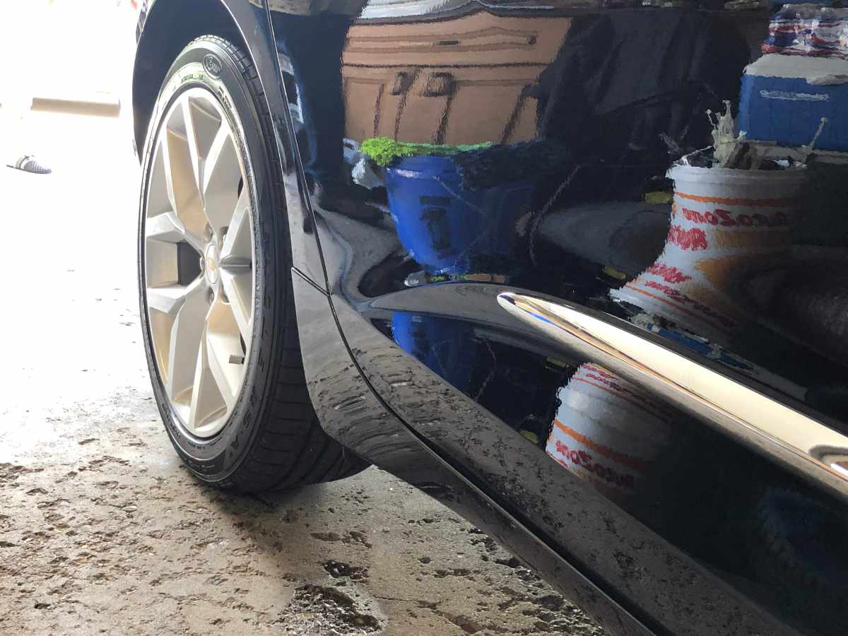 mirror finish black car reflecting a bucket