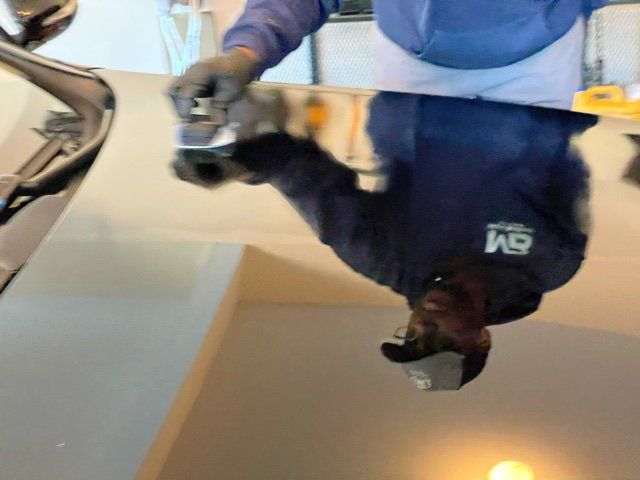 mans reflection in a mirror finished hood