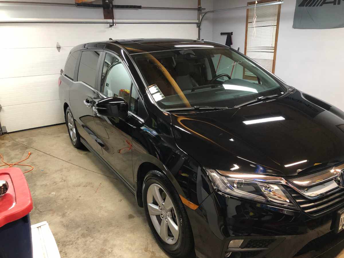 Black Honda Odyssey minivan parked inside a garage.