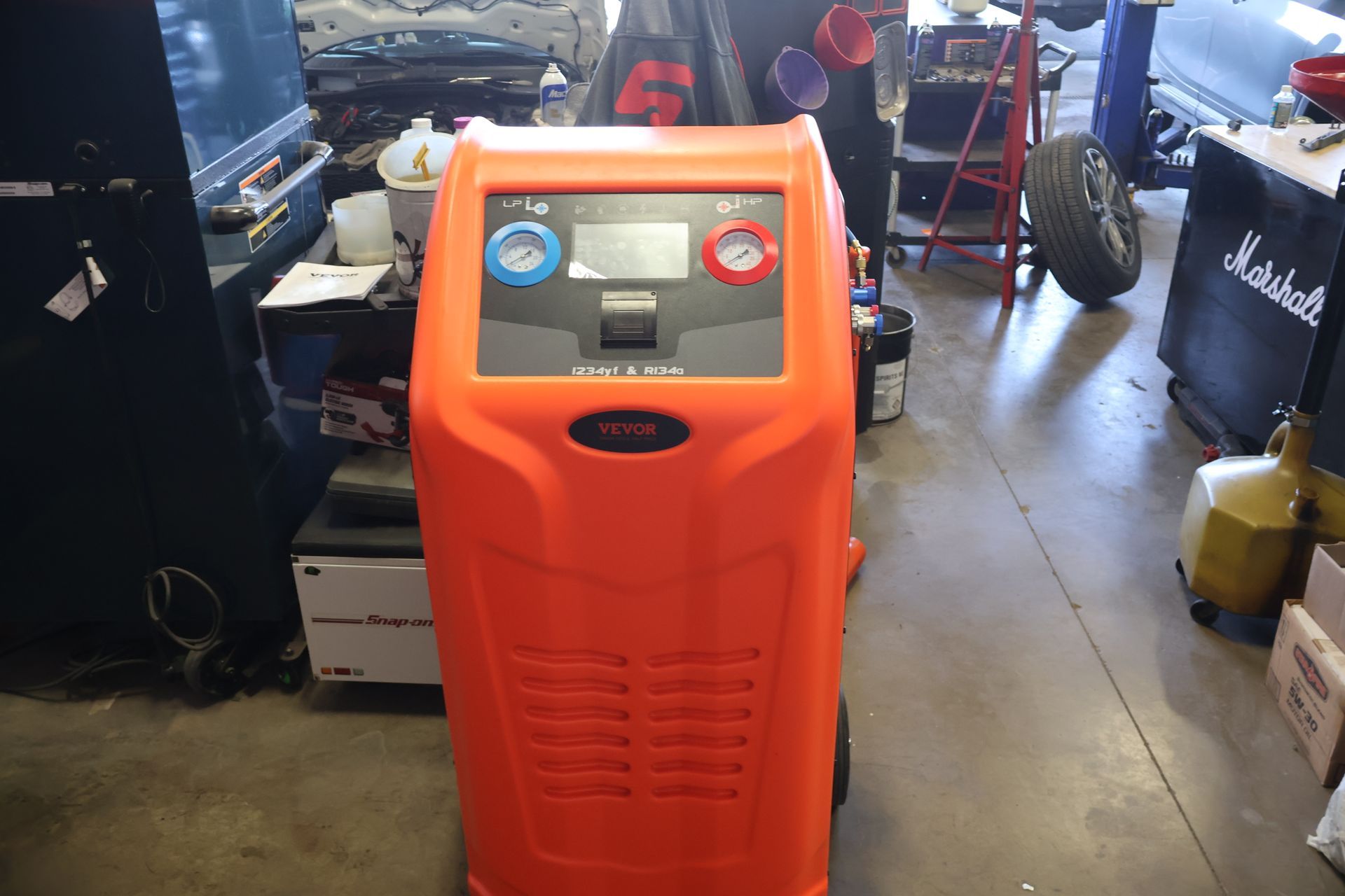 Orange automotive AC machine in a shop. | Findlay Auto Plus