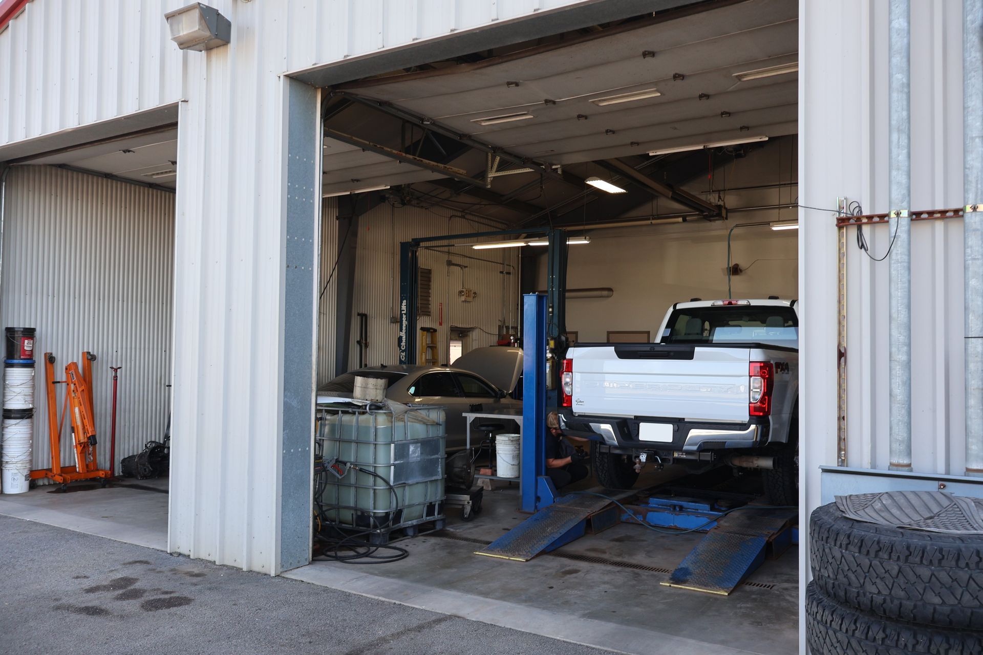 A garage bay with a pickup truck on a lift. Tools and equipment are visible. | Findlay Auto Plus