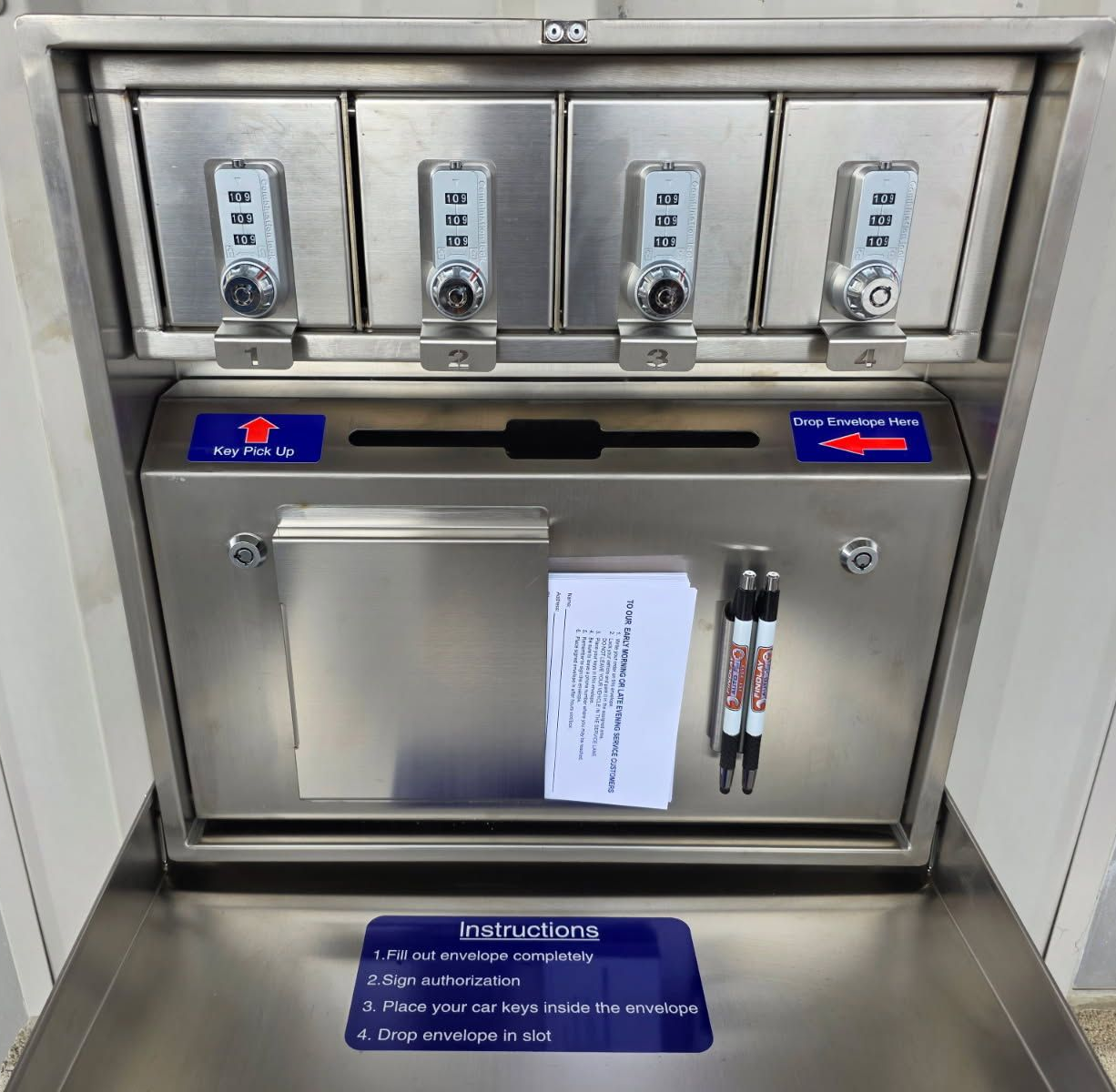 Metal locker station with four combination locks, instructions, and a slot for depositing items. | Findlay Auto Plus