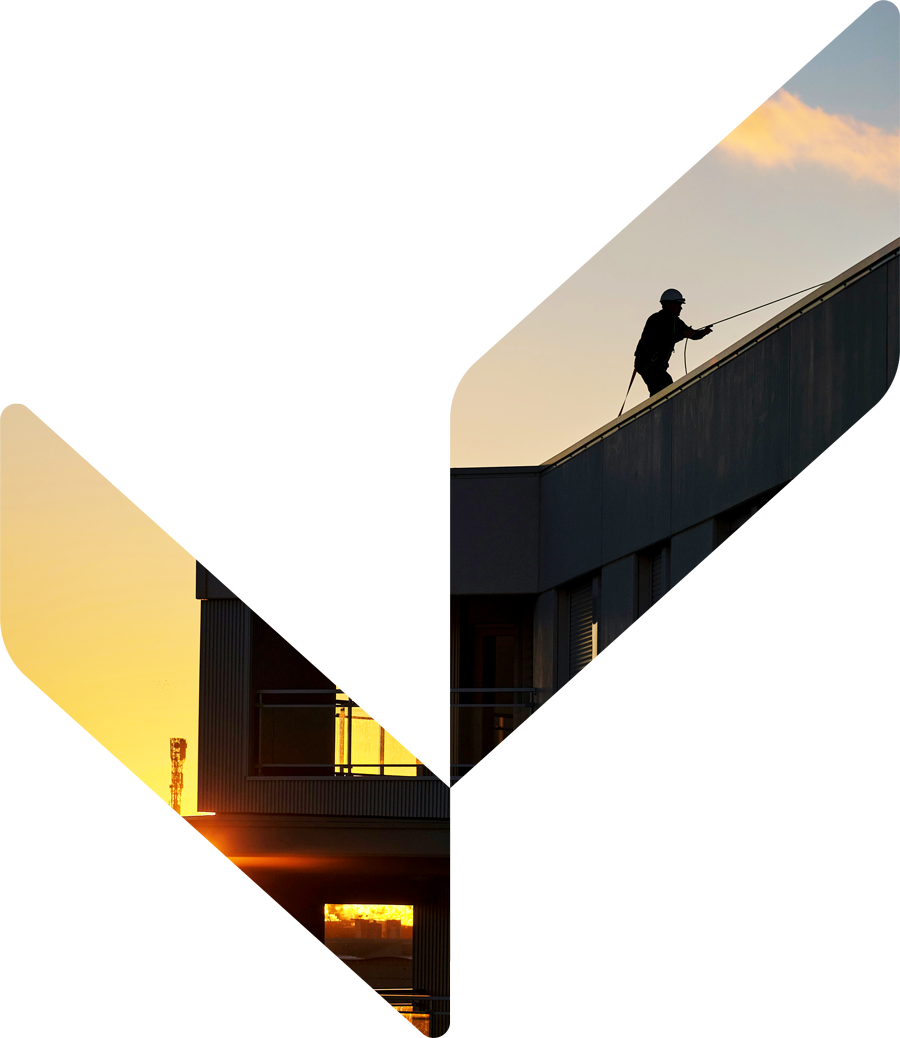 Building facade at sunset with worker on rooftop