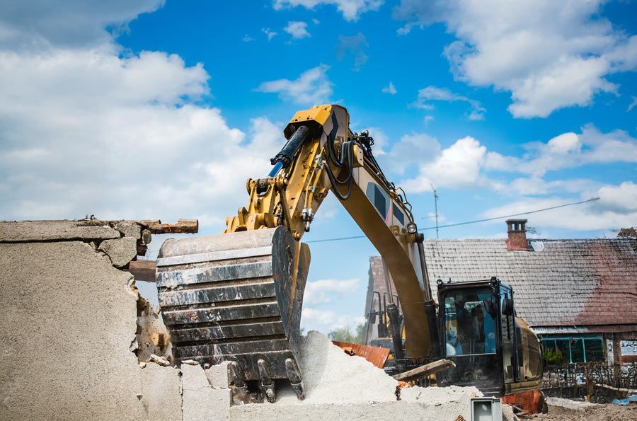Yellow excavator demolishing a building