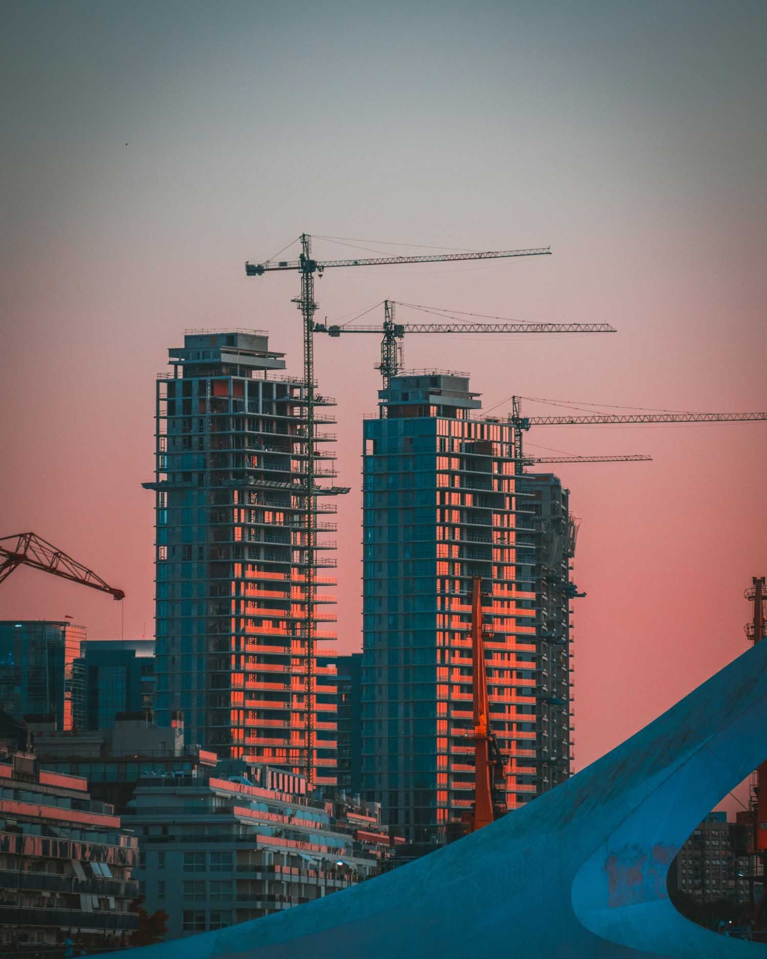 Skyscrapers under construction, and crane arms visible