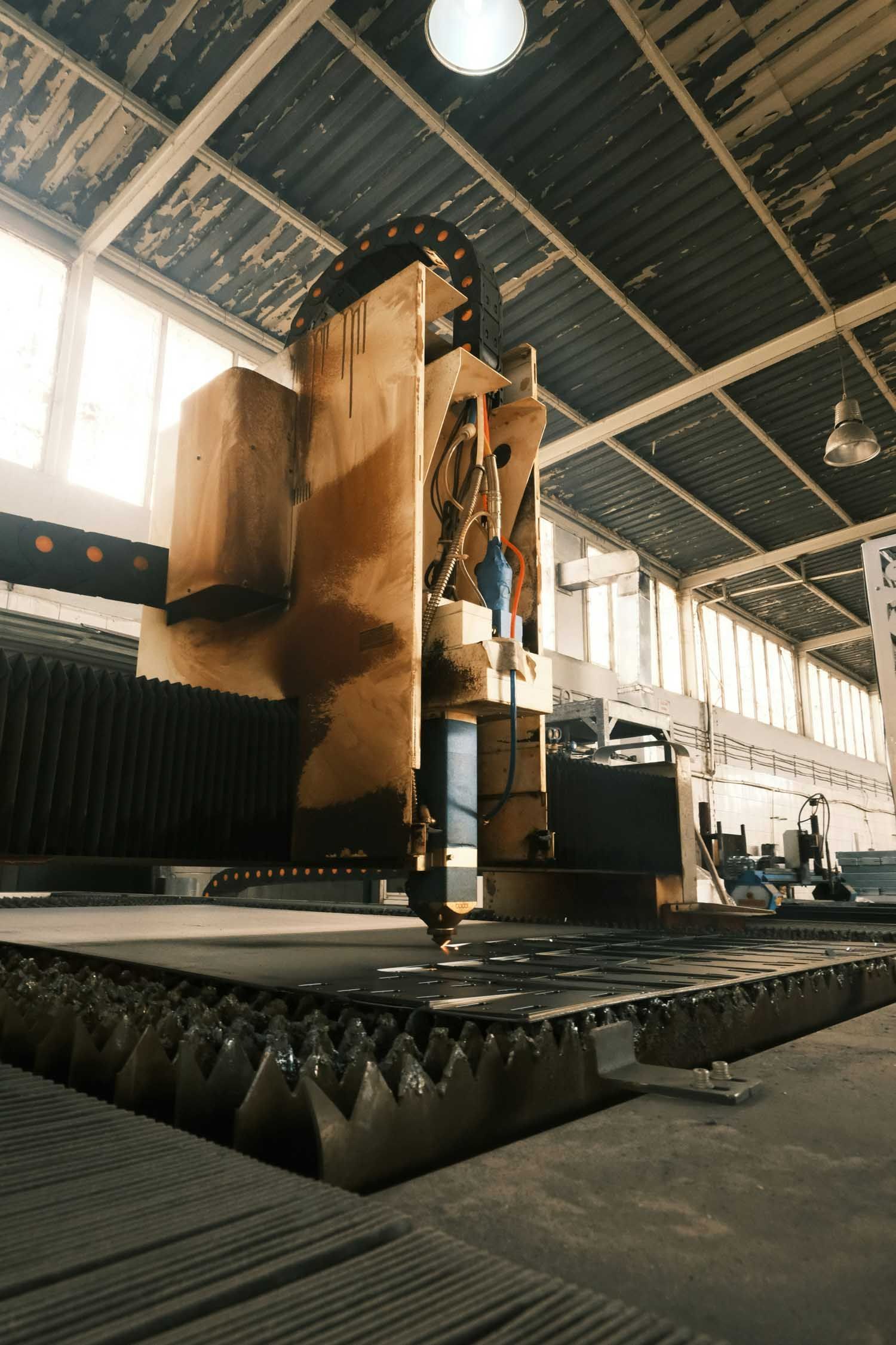 Large industrial machine cutting metal sheet in a factory
