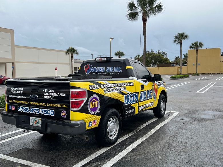 A yellow and black truck is parked in a parking lot.