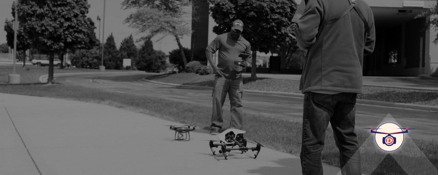 Two men preparing to fly two drones