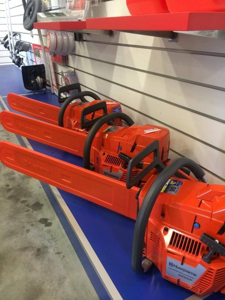 Three orange Husqvarna chainsaws lined up on a shelf — Gloucester Outdoor Solutions In Bulahdelah, NSW